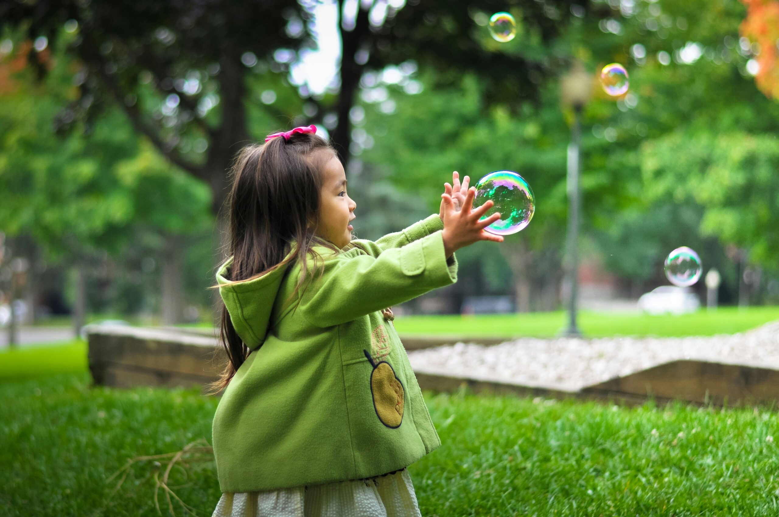A child catching bubbles outside.