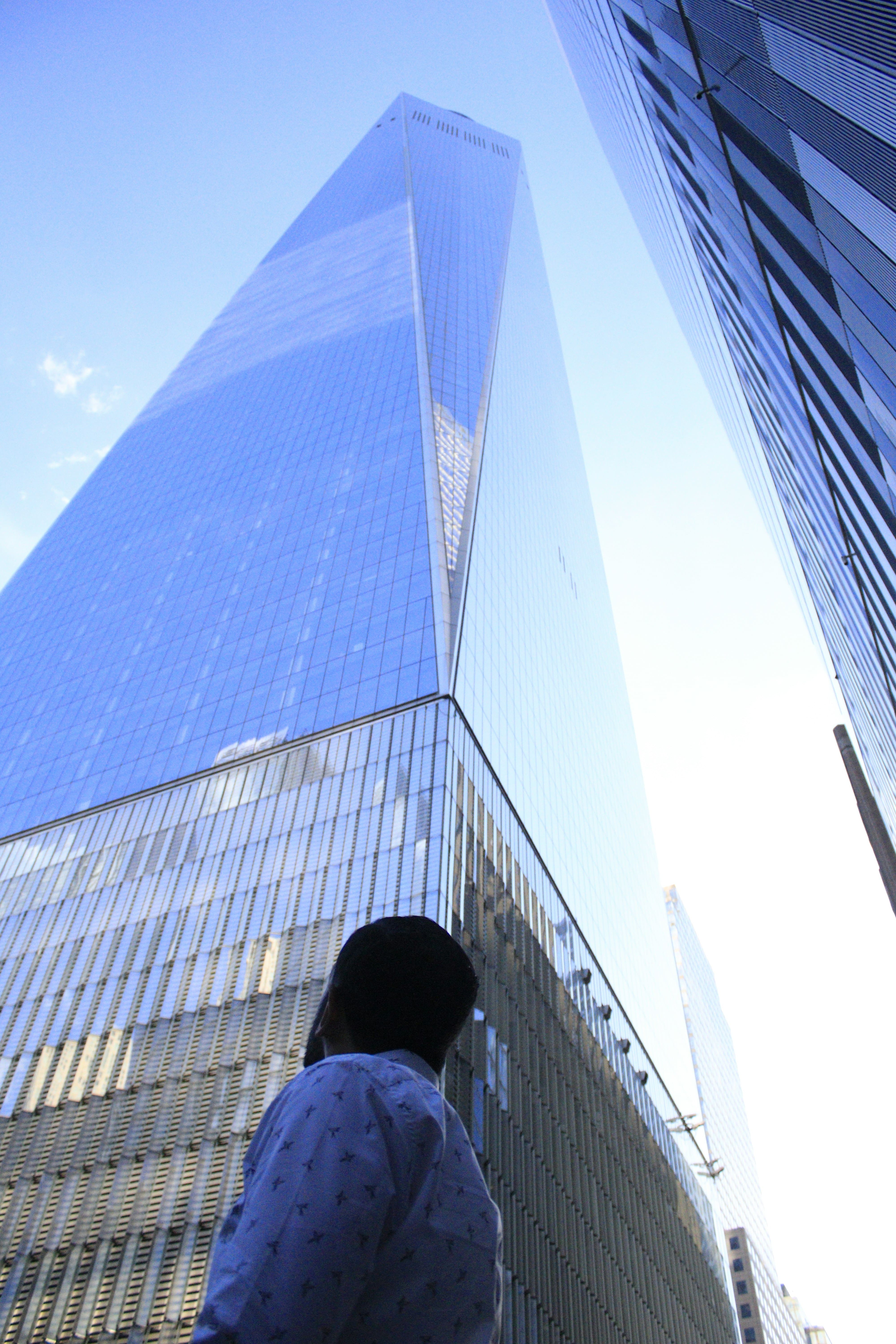 Man looking up at a building downtown.